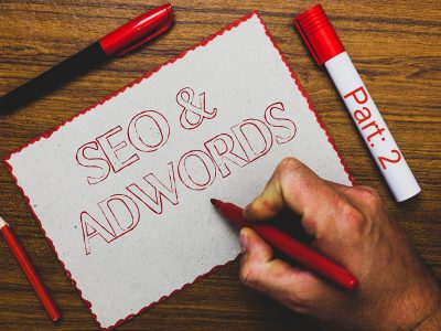 Word writing text Seo and Adwords. Business concept for Pay per click Digital marketing Google Adsense Man hand holding marker notebook paper expressing ideas wooden background.