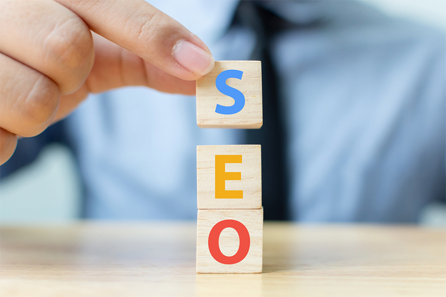 Search engine optimization concept. Hand putting wood block cube shape with word SEO