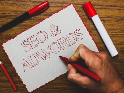 Word writing text Seo and Adwords. Business concept for Pay per click Digital marketing Google Adsense Man hand holding marker notebook paper expressing ideas wooden background.